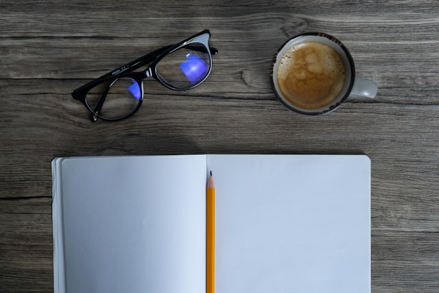 Notebook with coffee and glasses on a desk — symbolizing reflection and beginnings